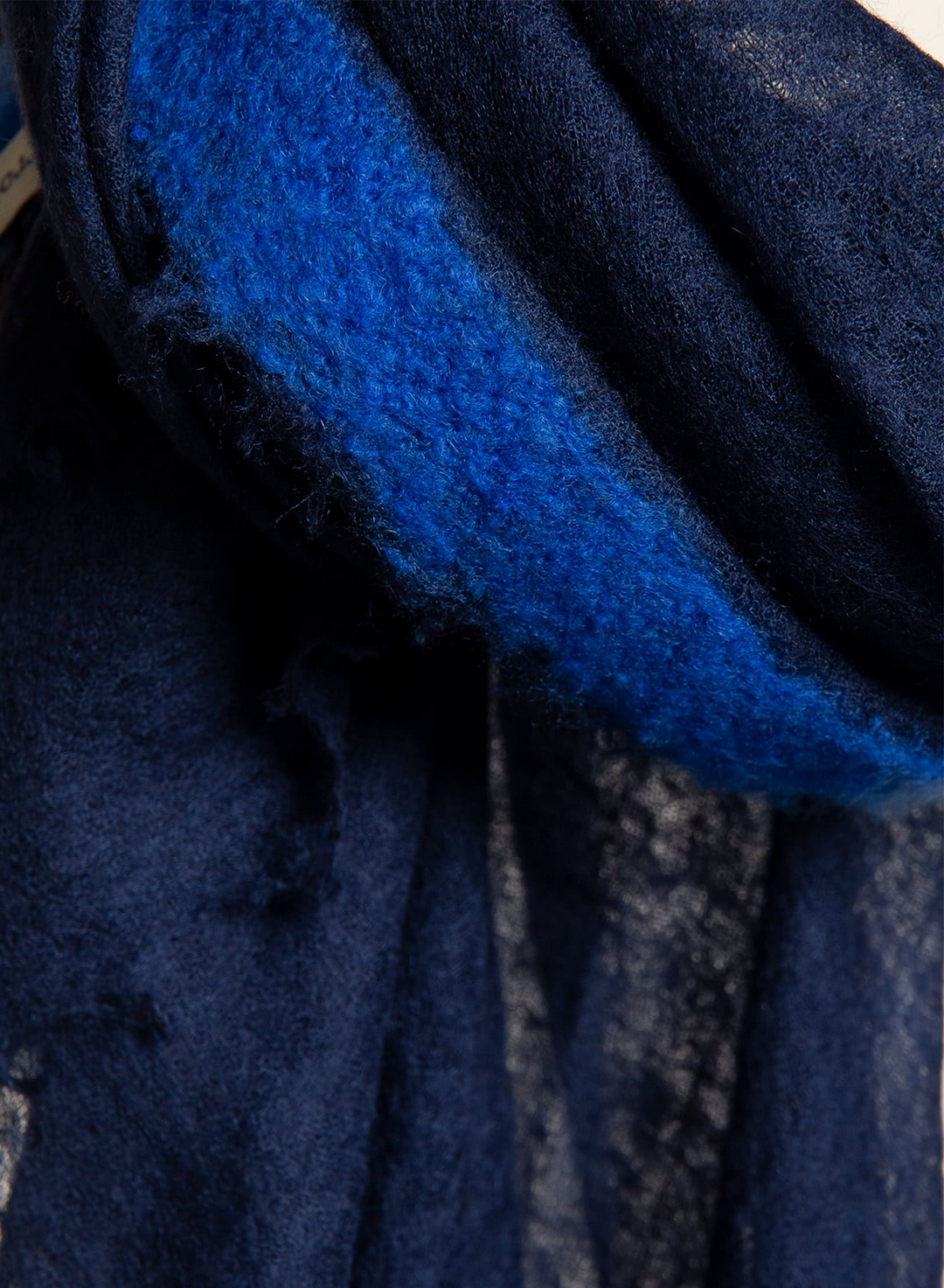 A close-up of a dark navy blue textured fabric with a bright royal blue fuzzy inner lining or backing.